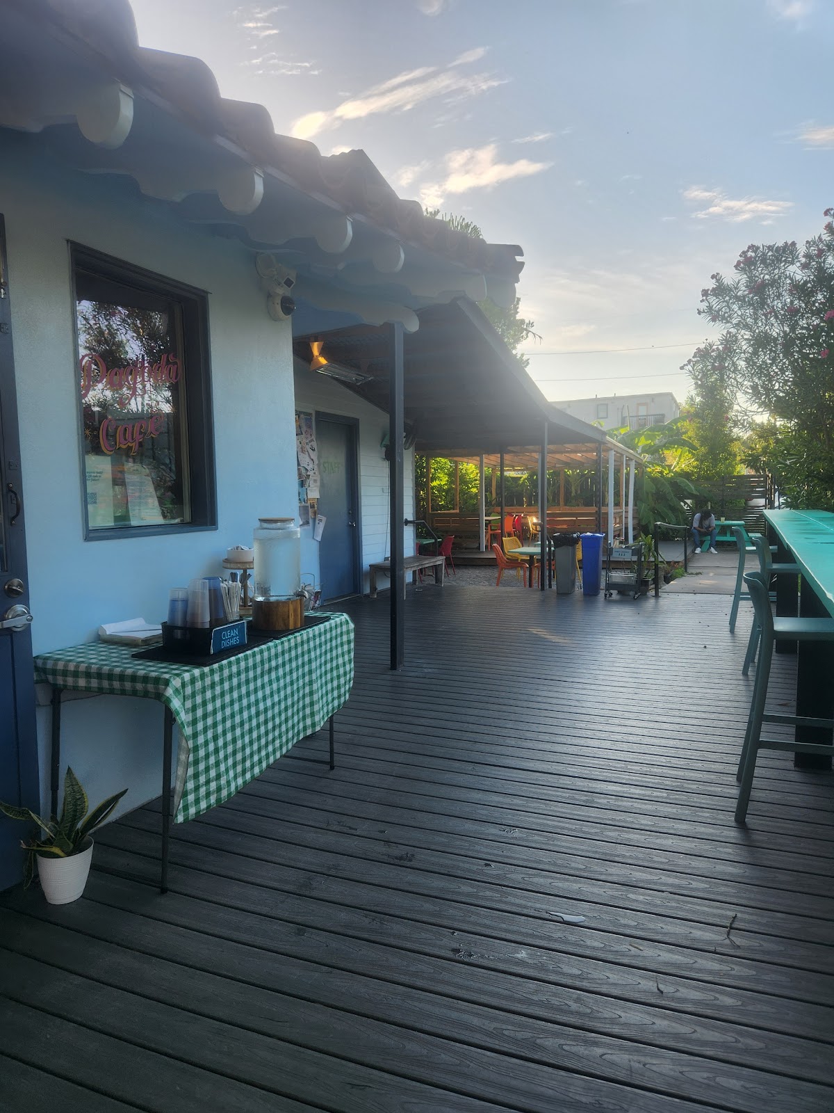 String lights and wooden tables in an outdoor cafe garden at golden hour